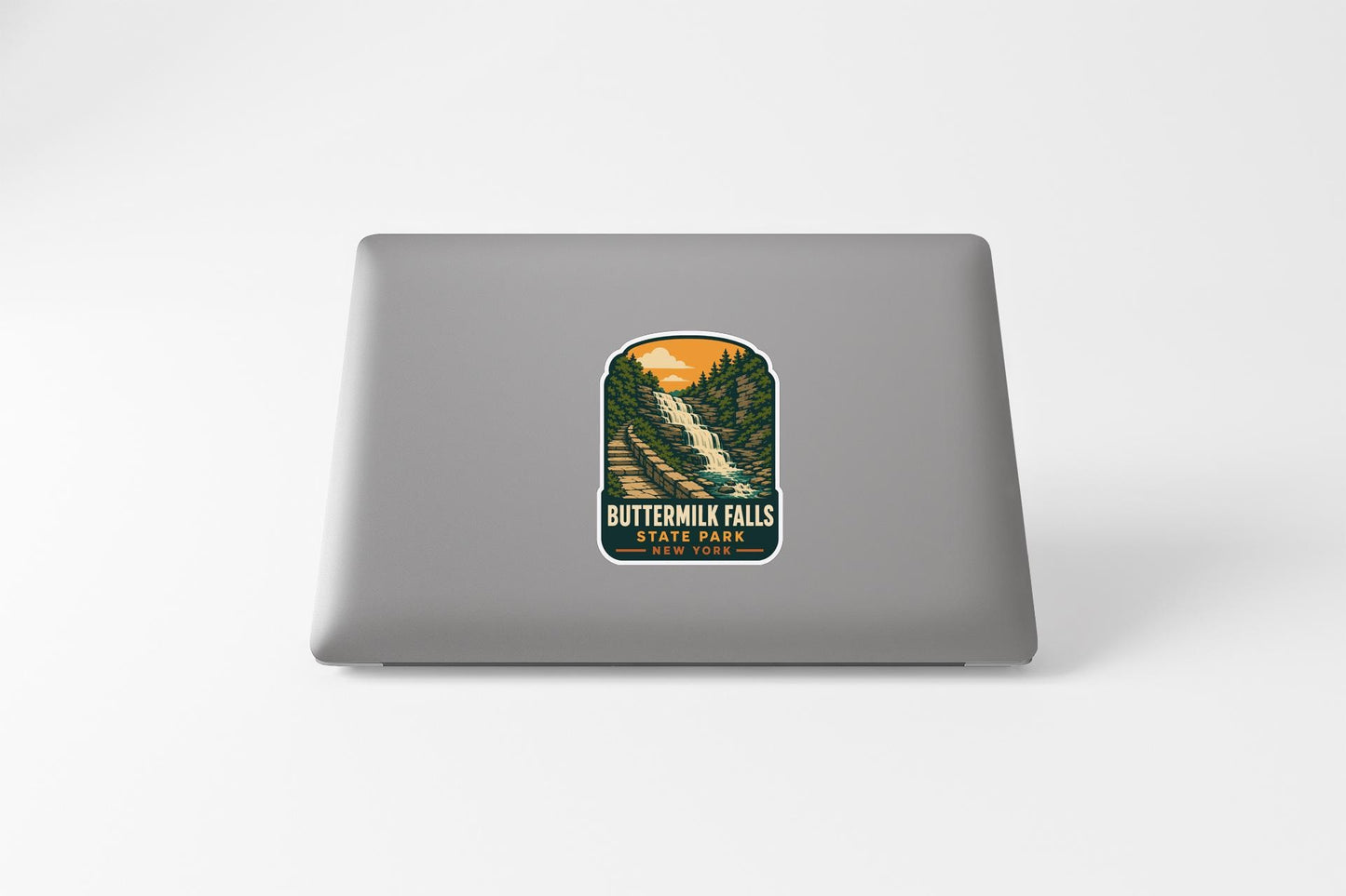 A sticker depicting Buttermilk Falls State Park on a laptop.
