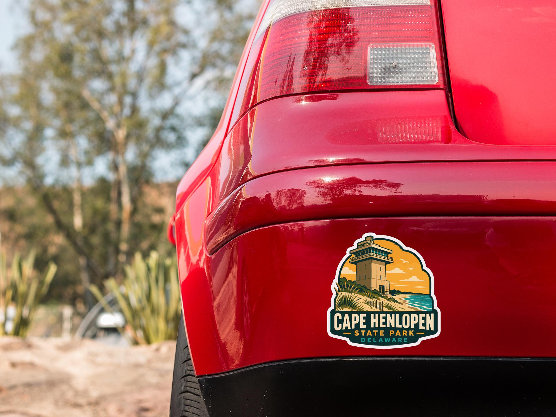 the rear end of a red car with a Cape Henlopen State Park sticker on the trunk.