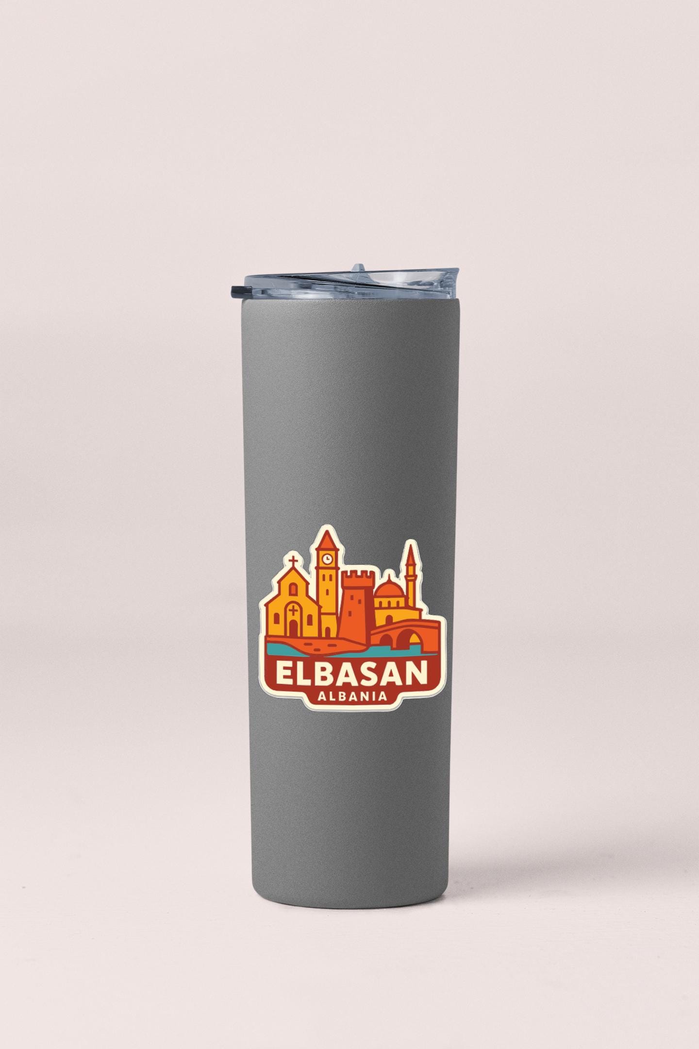 A gray insulated tumbler with a printed Elbasan, Georgia cityscape logo on it.