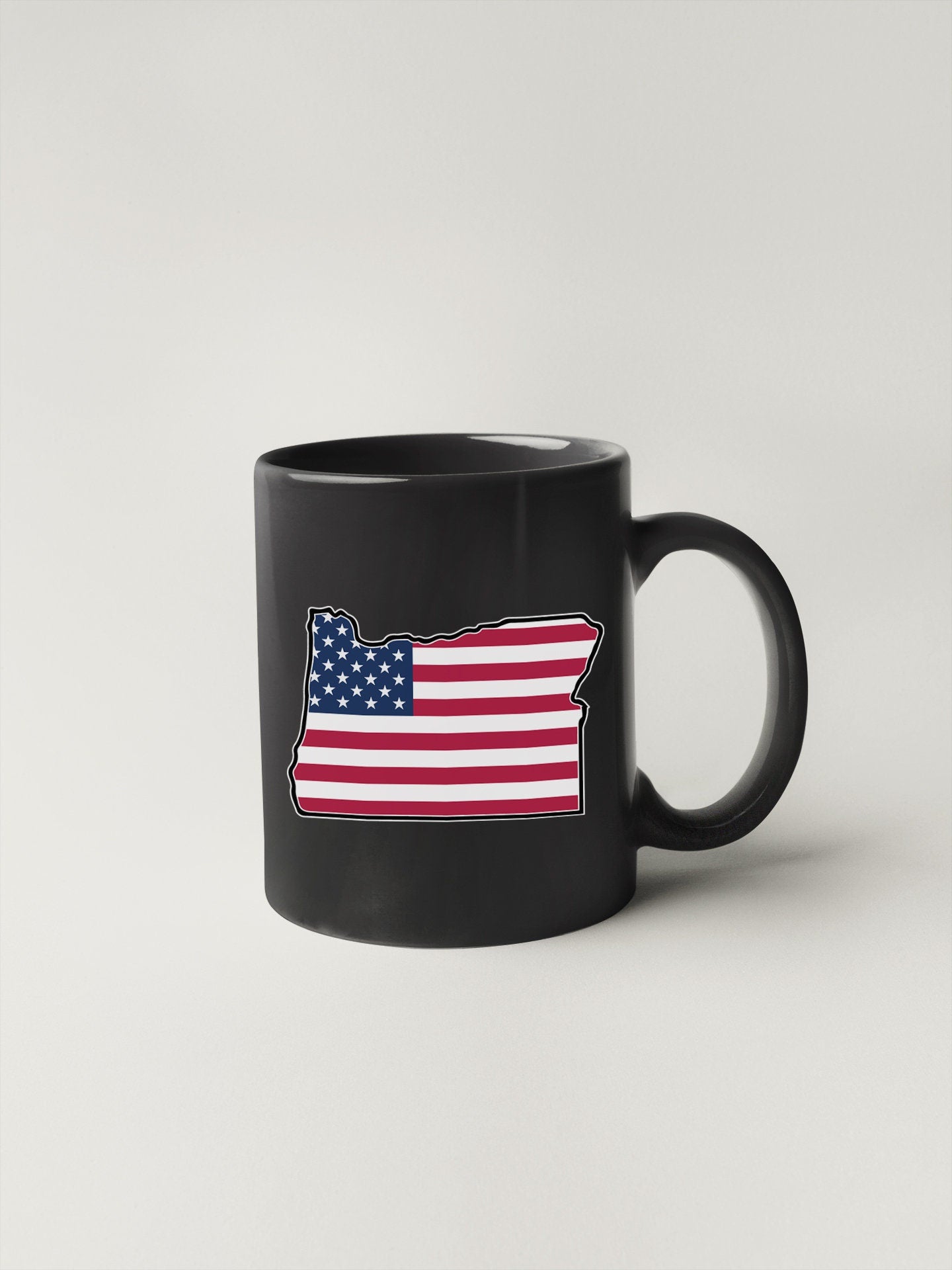 a black coffee mug with an american flag on it