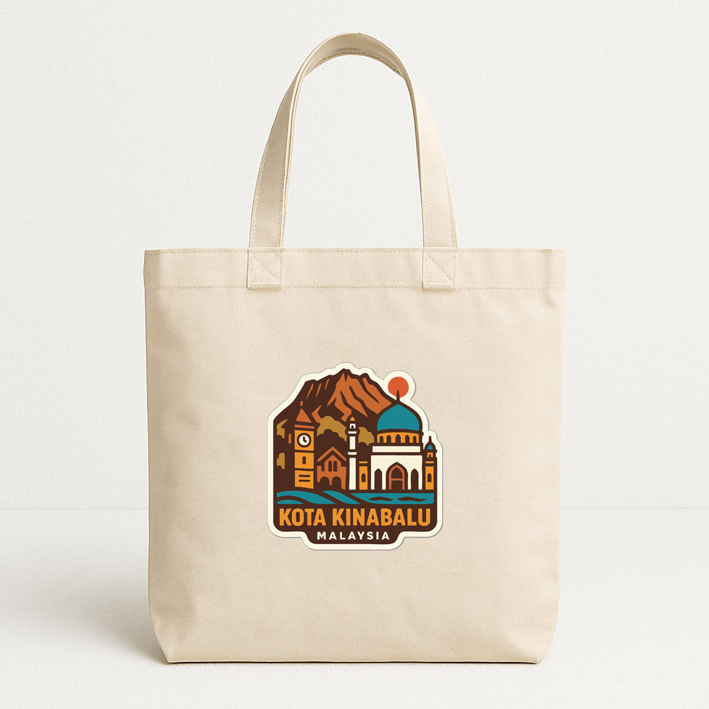 A beige tote bag with a printed design depicting a cityscape and a mountain, along with the text "KOTA KINABALU MALAYSIA".