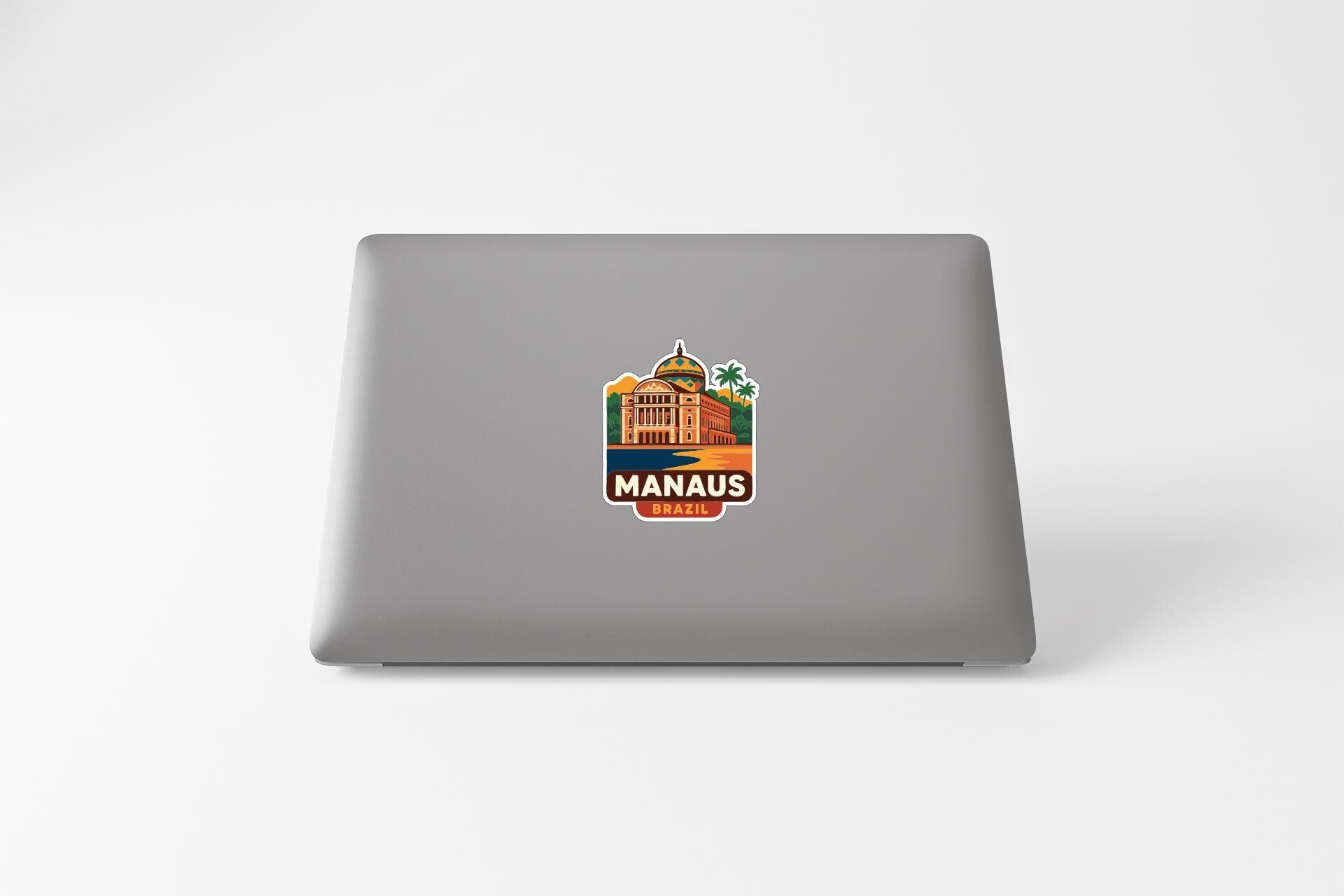 a sticker with a building and palm trees on a laptop.