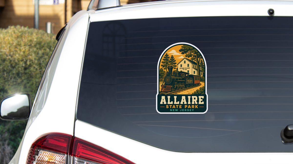 A sticker on the rear window of a car, depicting a scenic train and the text "ALLAIRE STATE PARK NEW JERSEY".