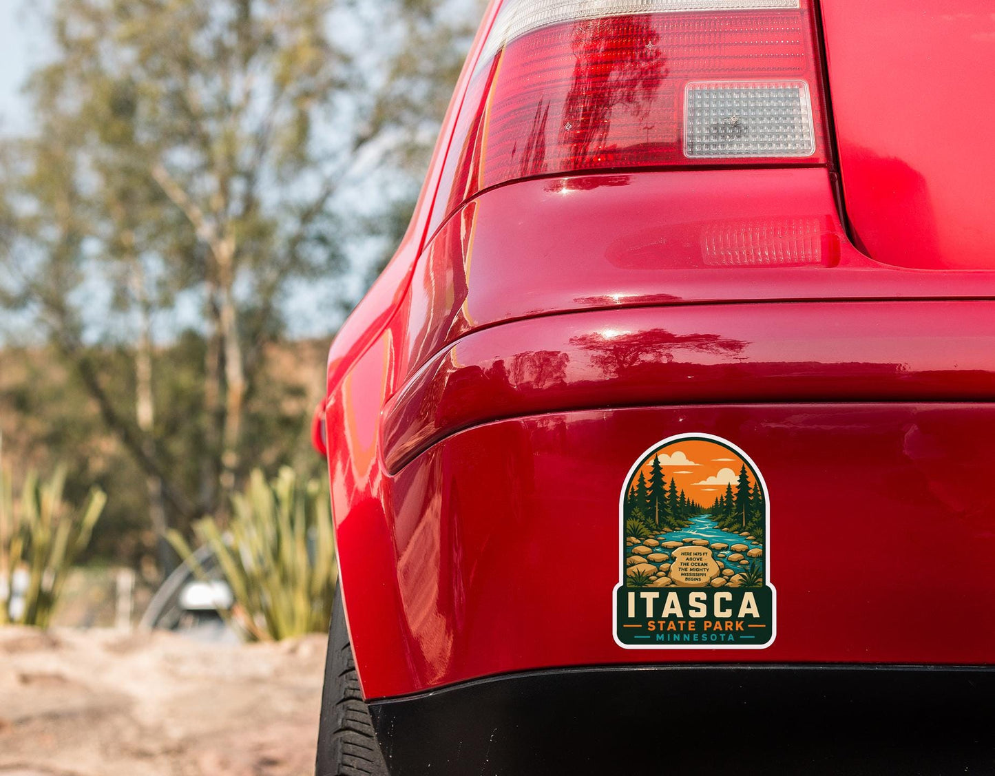 the rear end of a red car with a sticker on the trunk that says "ITASCA ITALES, MINNESOTA".