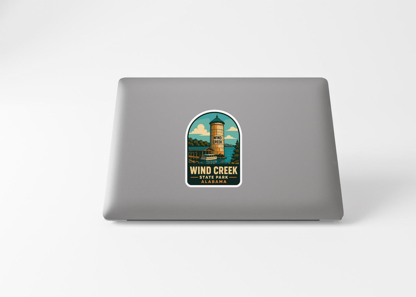 a sticker with a graphic of a tower and the text "WIND CREEK" and "ALASKA PARK" printed on a laptop.