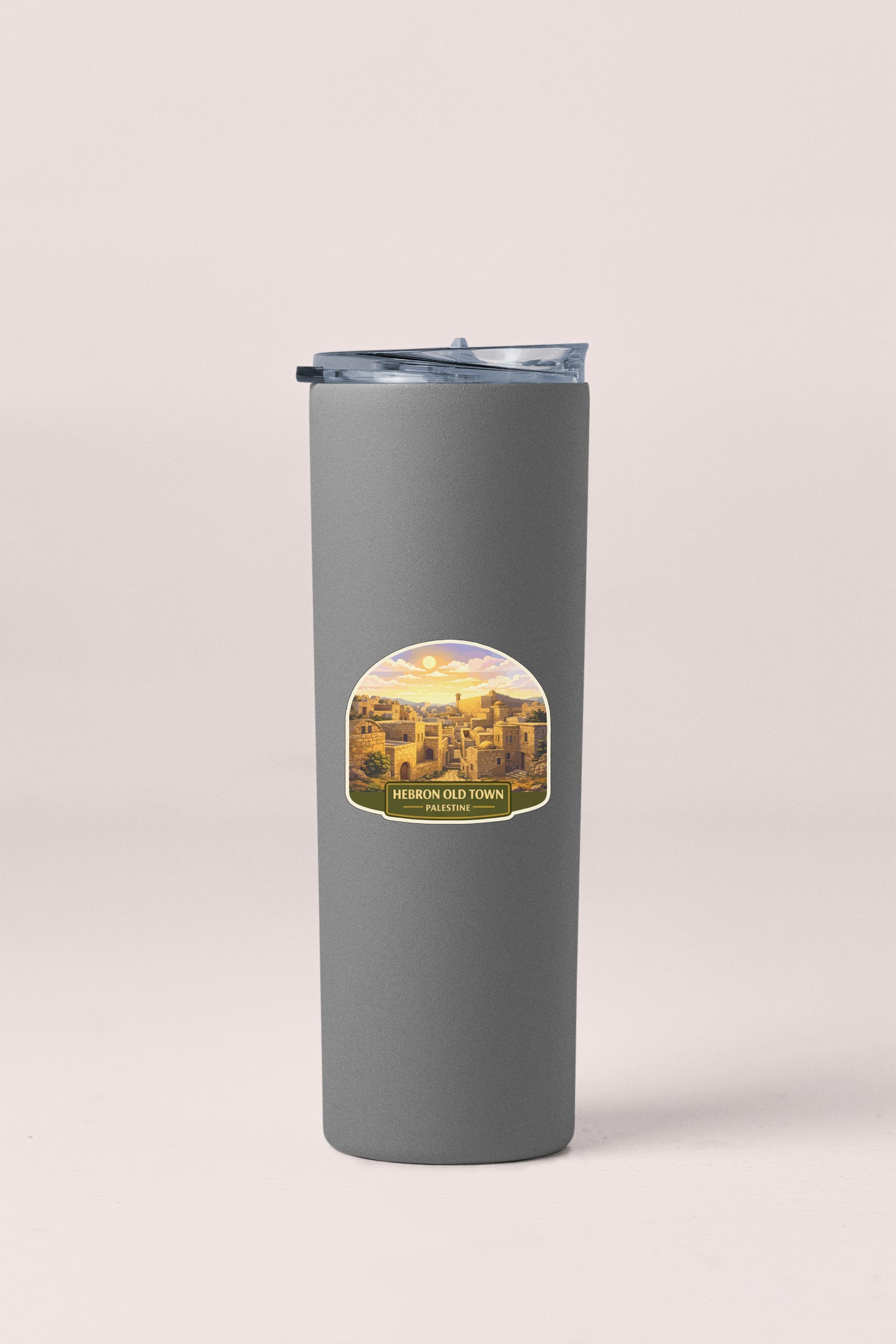 A gray insulated tumbler with a label depicting a scenic view of a town.