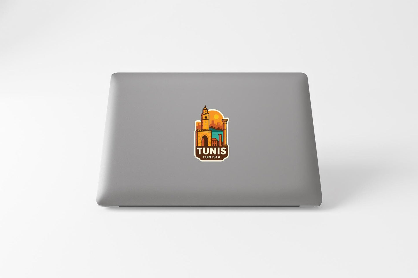 A sticker with an illustration of a building and the text "TUNIS" on a laptop.
