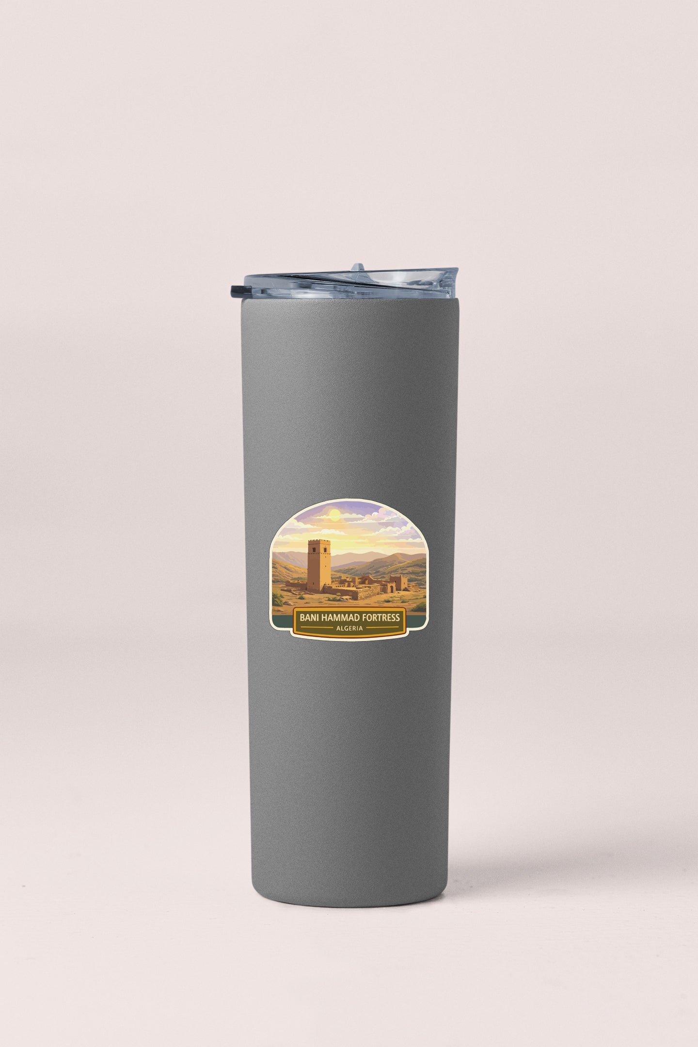 A gray insulated tumbler with a label featuring a scenic image of a castle or fortification.