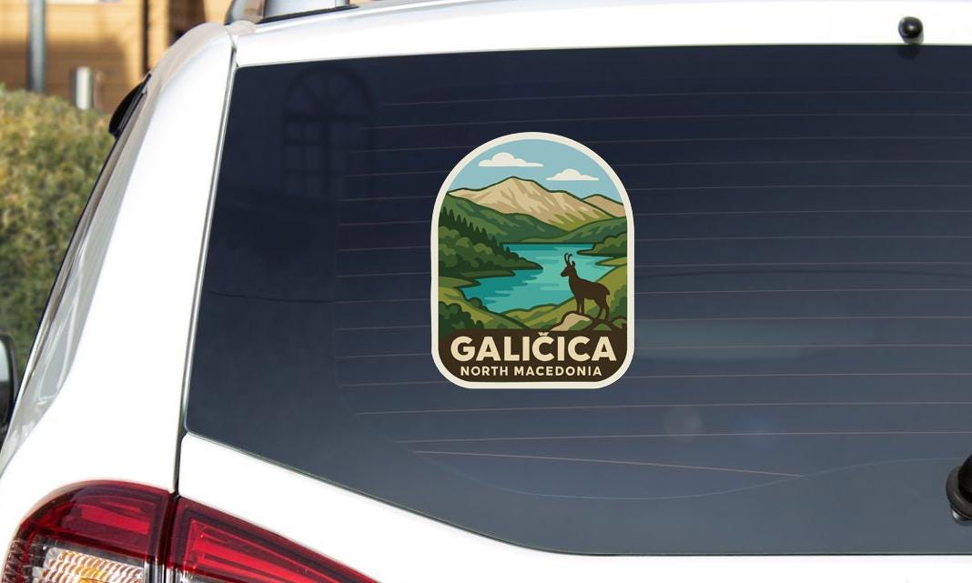 a sticker on the rear window of a car that displays a scenic landscape with mountains, a river, and a deer.