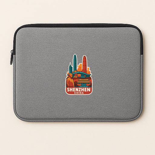 A gray laptop sleeve with a sticker of a city skyline and the text "Shenzhen China" printed on it.