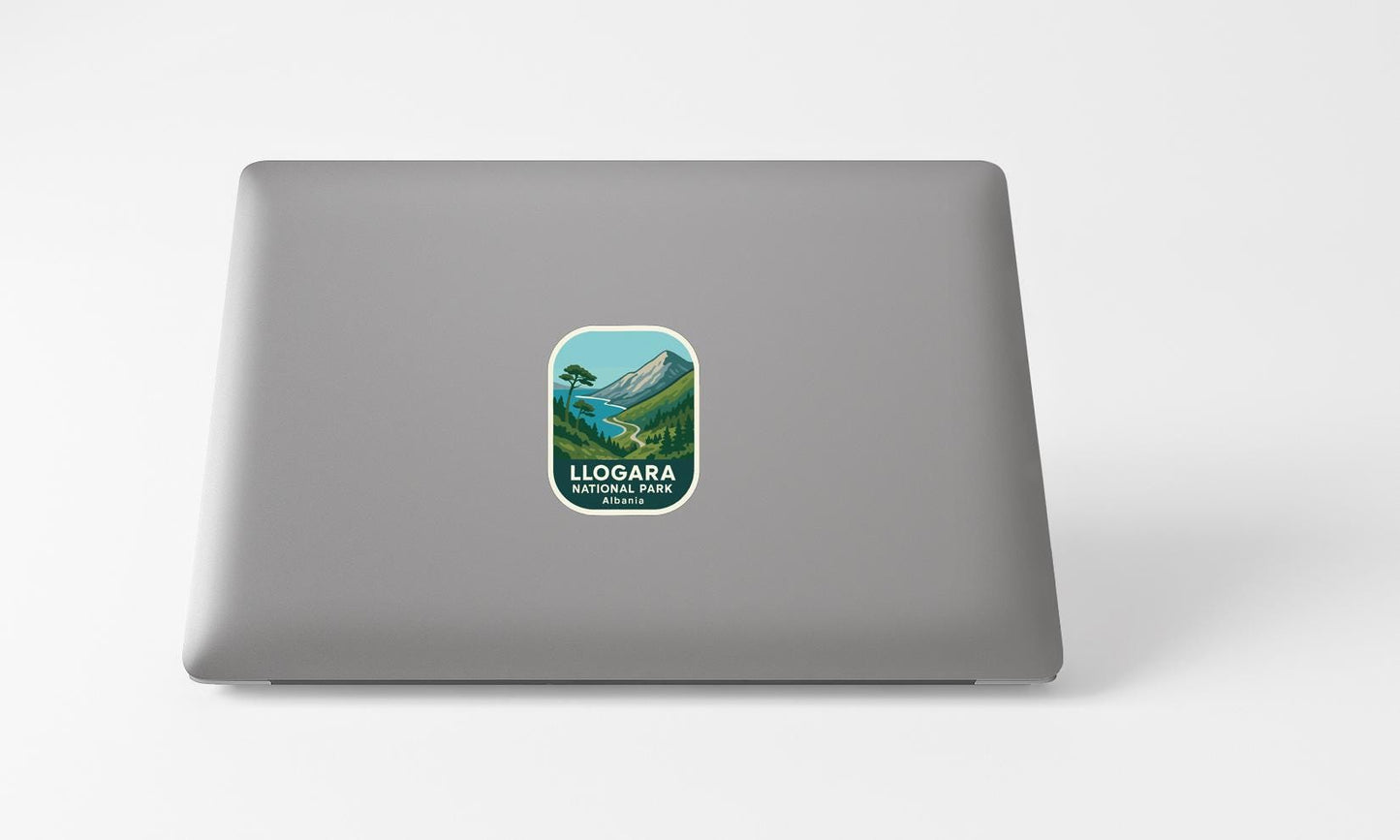 A sticker with a mountain landscape and the text "LLOGARA NATIONAL PARK AUSTIN, TX" printed on a grey laptop.