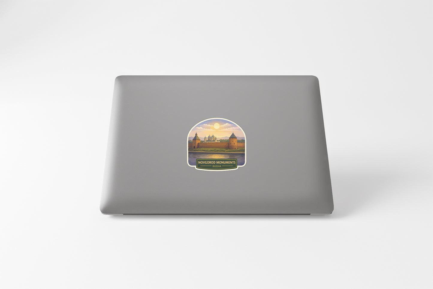 a laptop with a sticker on the back cover, depicting a scenic view of a castle or palace surrounded by a body of water.