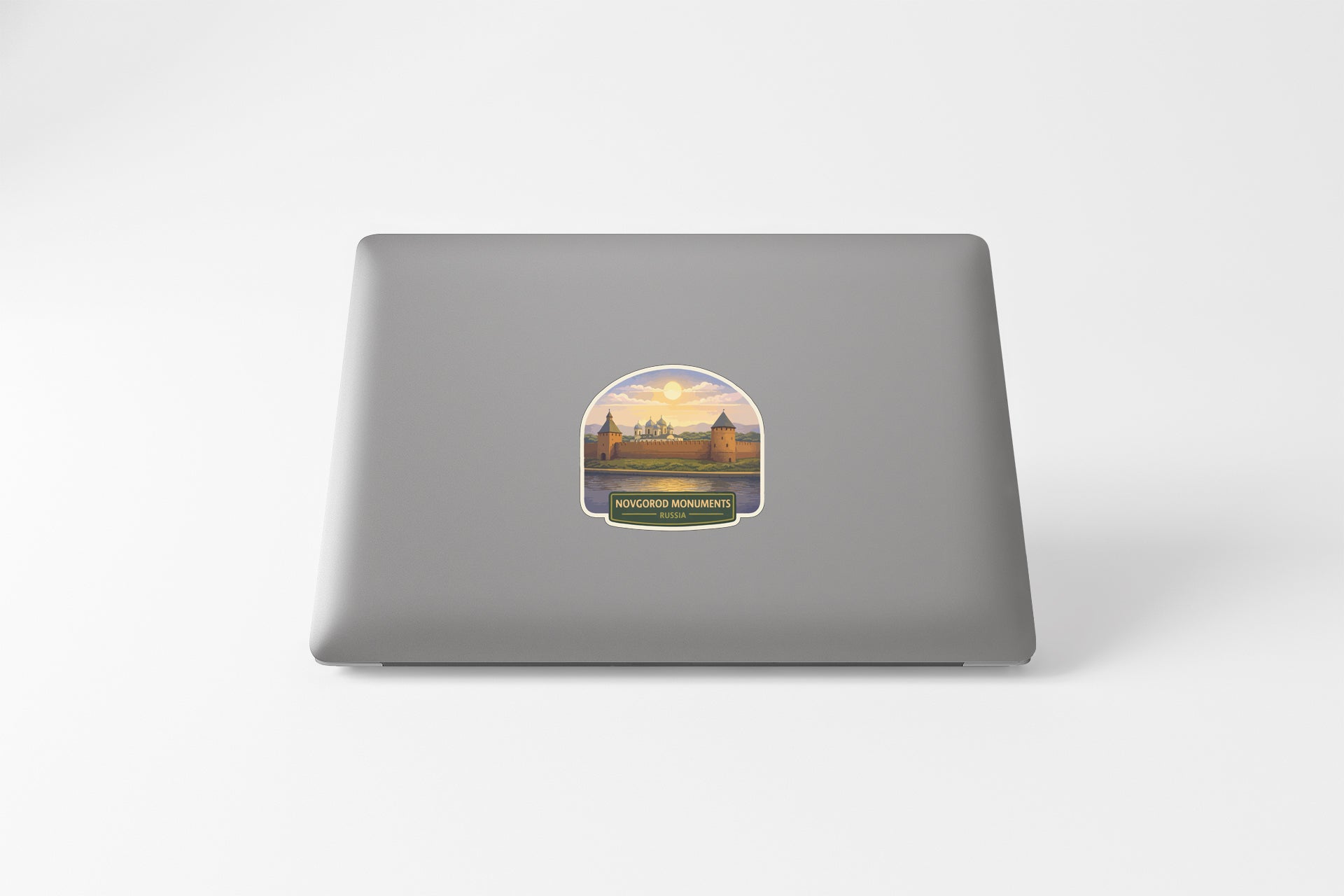 a laptop with a sticker on the back cover, depicting a scenic view of a castle or palace surrounded by a body of water.
