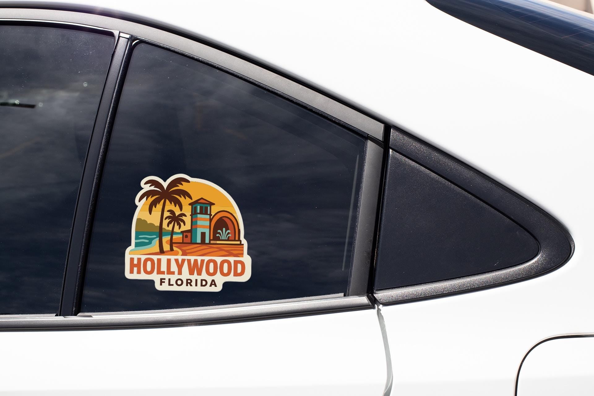 A sticker on the side of a car window, depicting a tropical beach scene with palm trees and a building, representing the location of Hollywood, Florida.