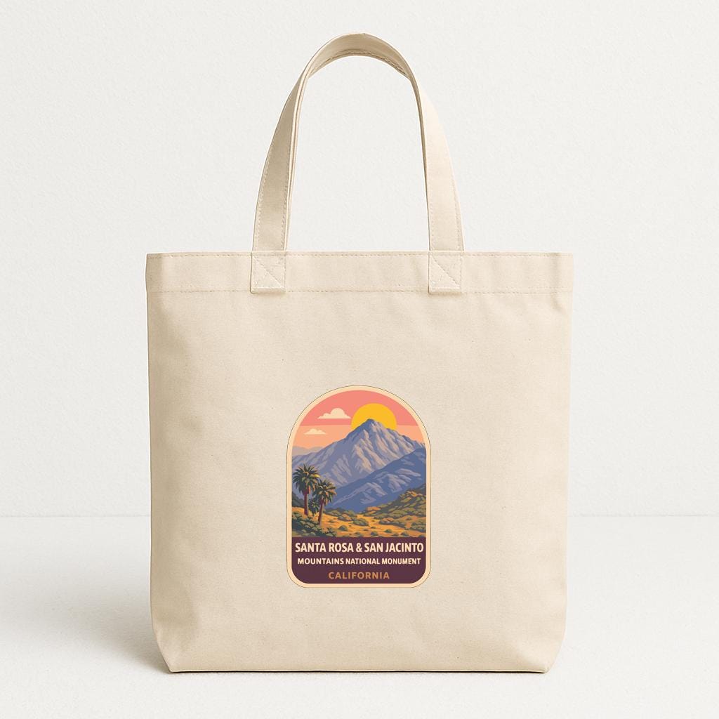 A beige tote bag with a printed label that says "SANTA ROSA & SAN JACINIO MOUNTAIN NATIONAL MONUMENT CALIFORNIA".