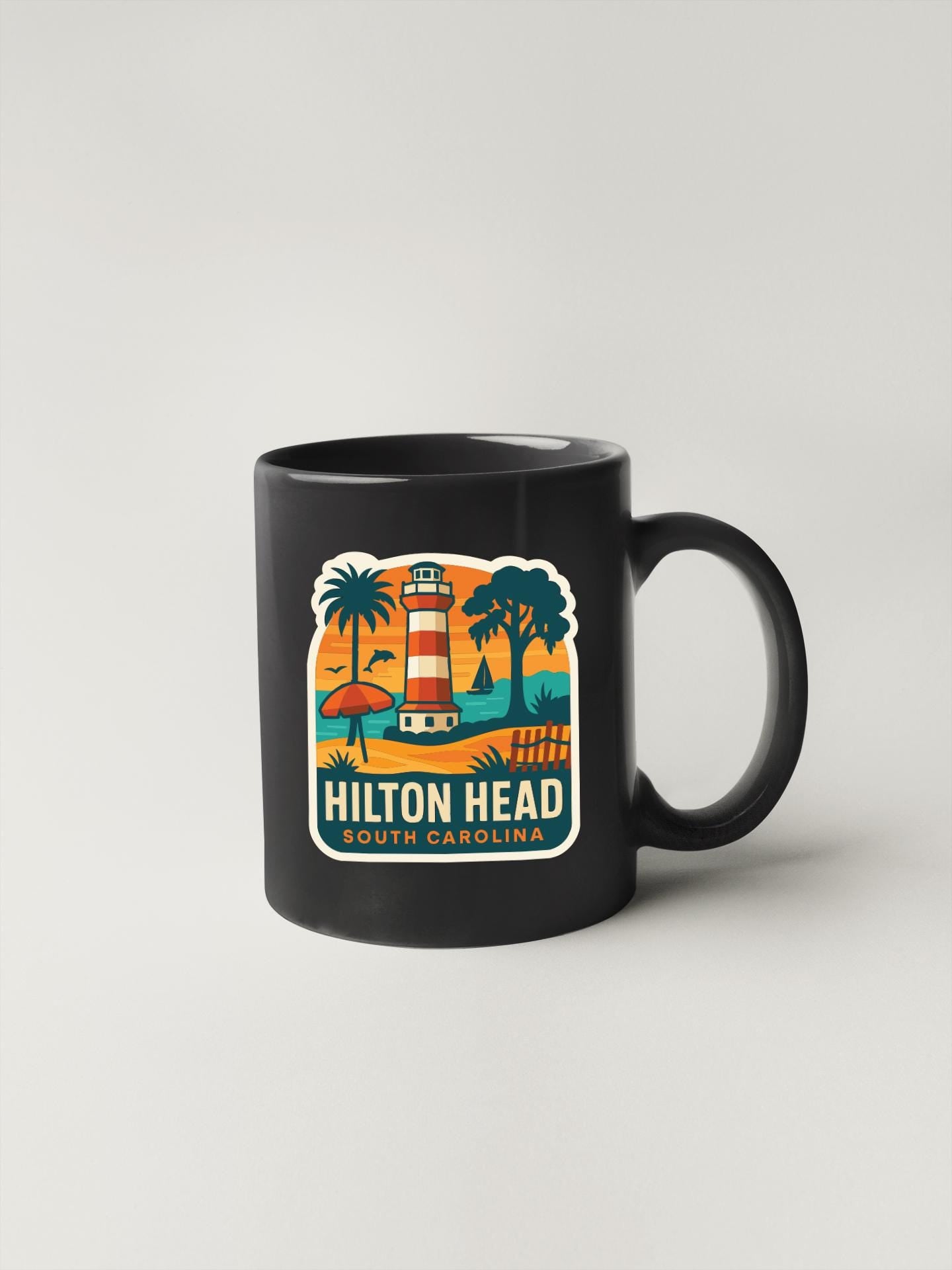 A black coffee mug with a colorful graphic design depicting a lighthouse and palm trees, along with the text "Hilton Head South Carolina".