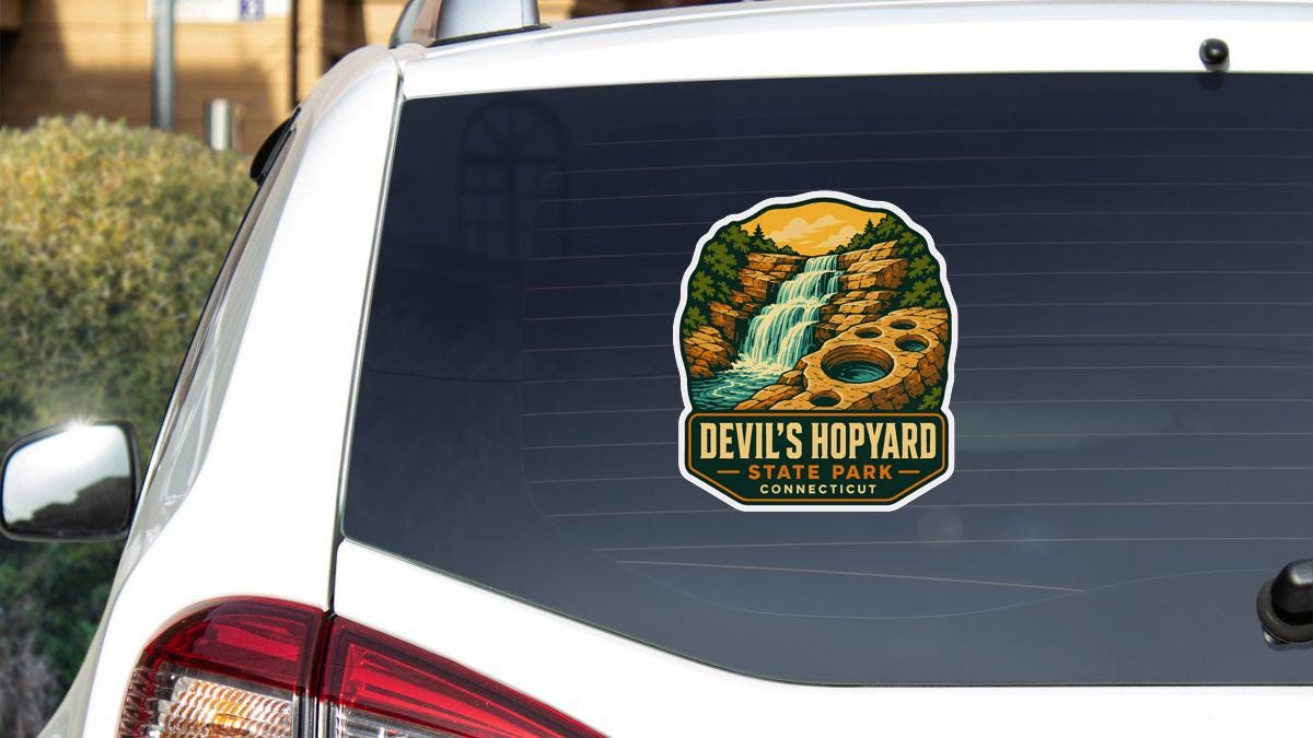 a sticker on the rear window of a white car, depicting a scenic landscape with a waterfall and a forest.