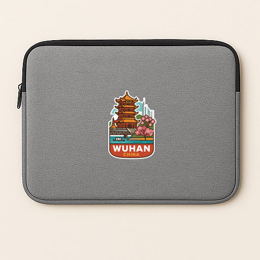 A gray laptop sleeve with a sticker depicting a temple and the text "WUHAN" printed on it.