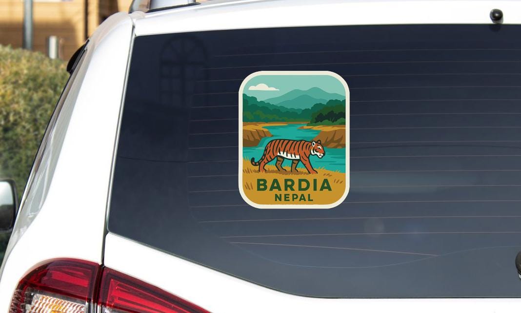 A sticker on the rear window of a car, depicting a tiger in a natural landscape with mountains in the background.