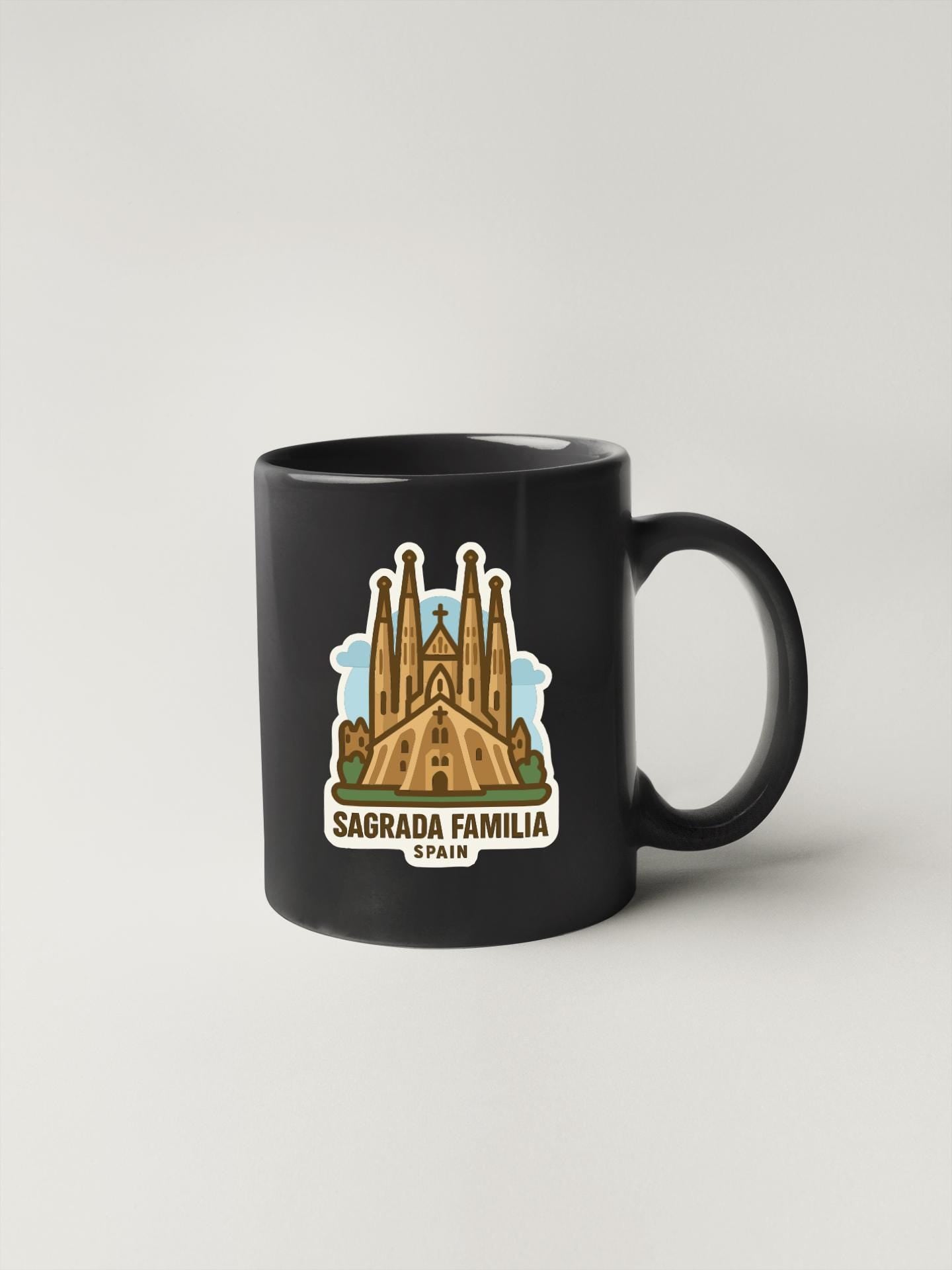 A black coffee mug with a graphic of the Sagrada Familia, a famous cathedral in Barcelona, Spain.