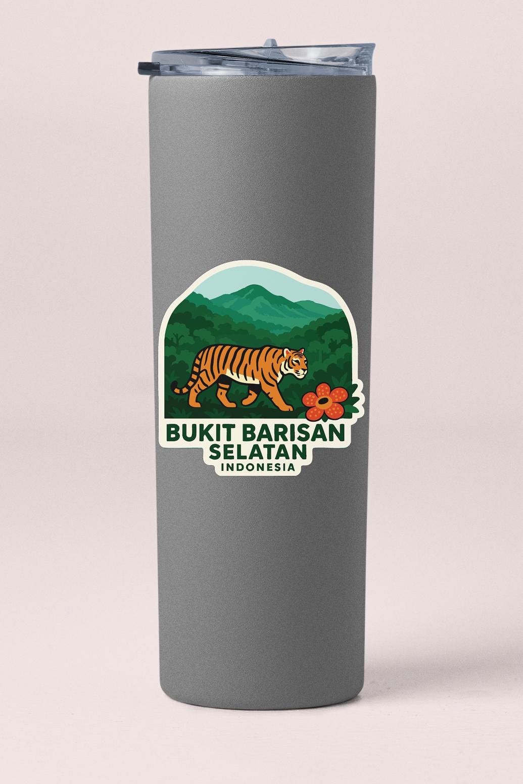 A gray insulated tumbler with a sticker depicting a tiger in a jungle setting.