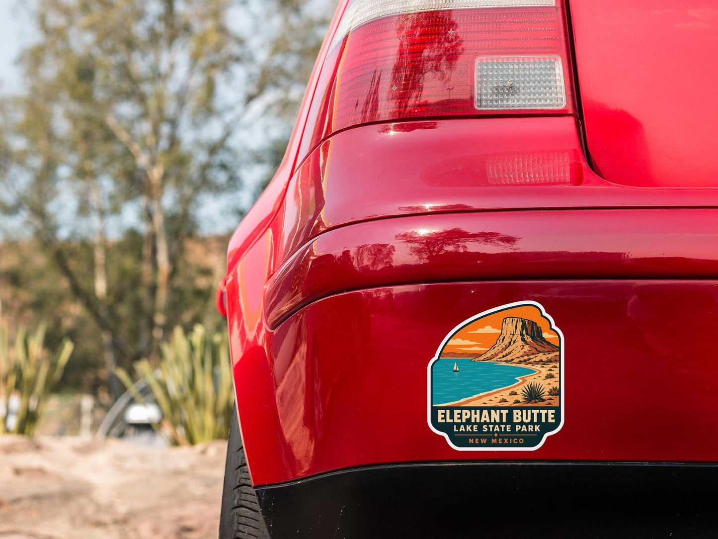the rear end of a red car with a sticker on the back window that says "Elephant Butte Lake State Park New Mexico".