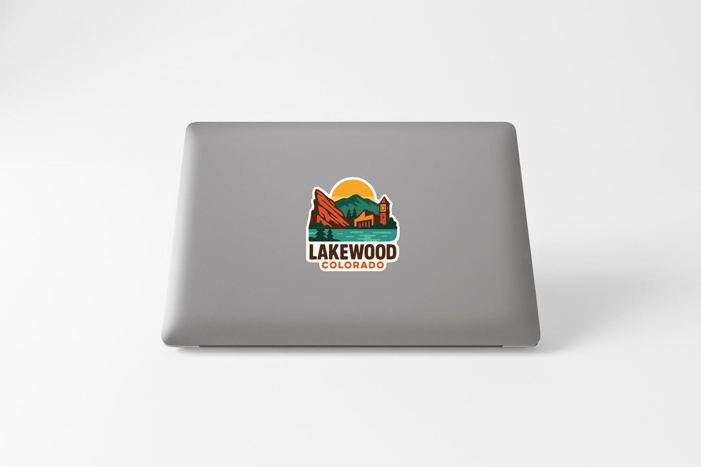 a sticker with a mountain landscape and the text "LAKEWOOD COLORADO" on the back of a laptop.