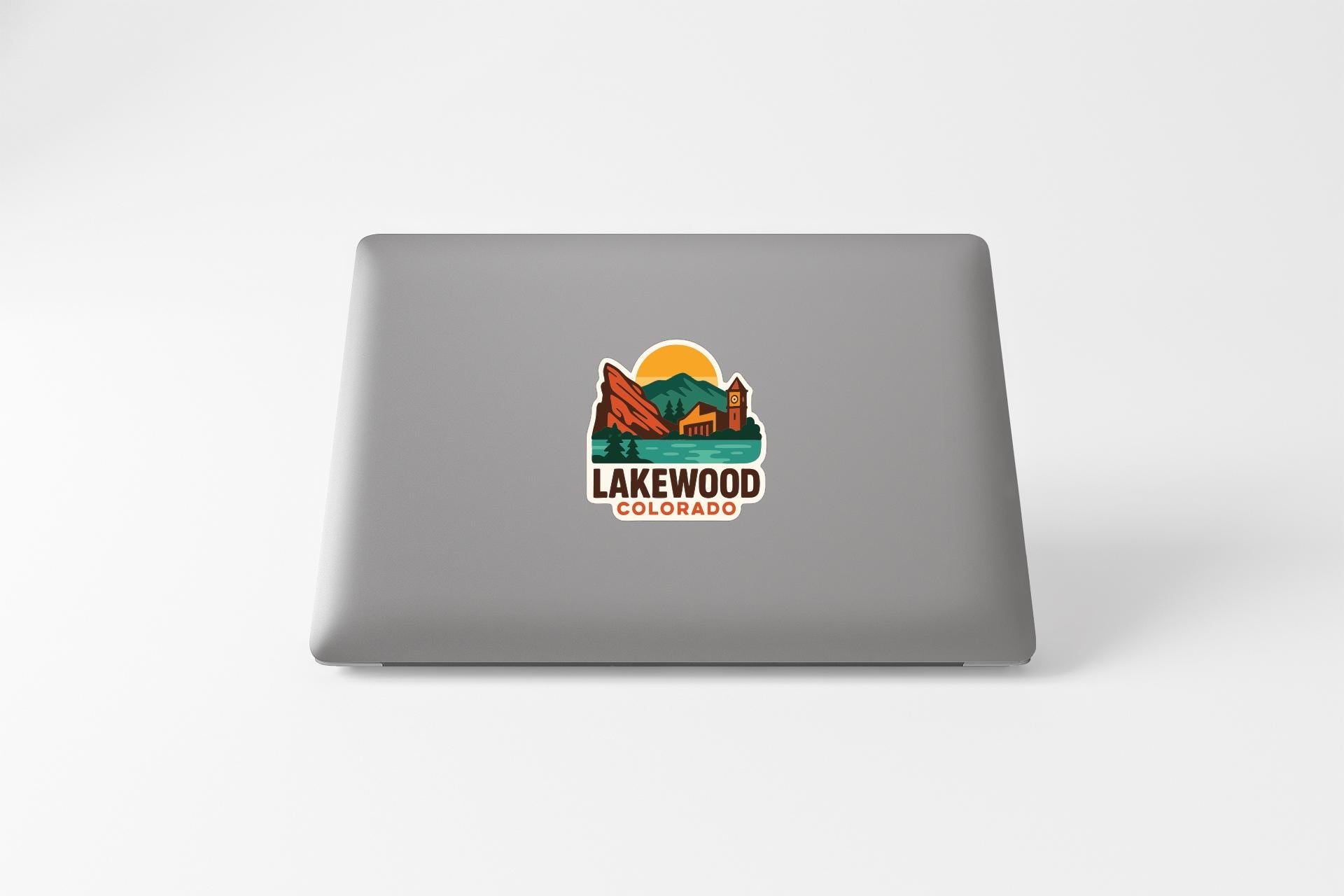 a sticker with a mountain landscape and the text "LAKEWOOD COLORADO" on the back of a laptop.