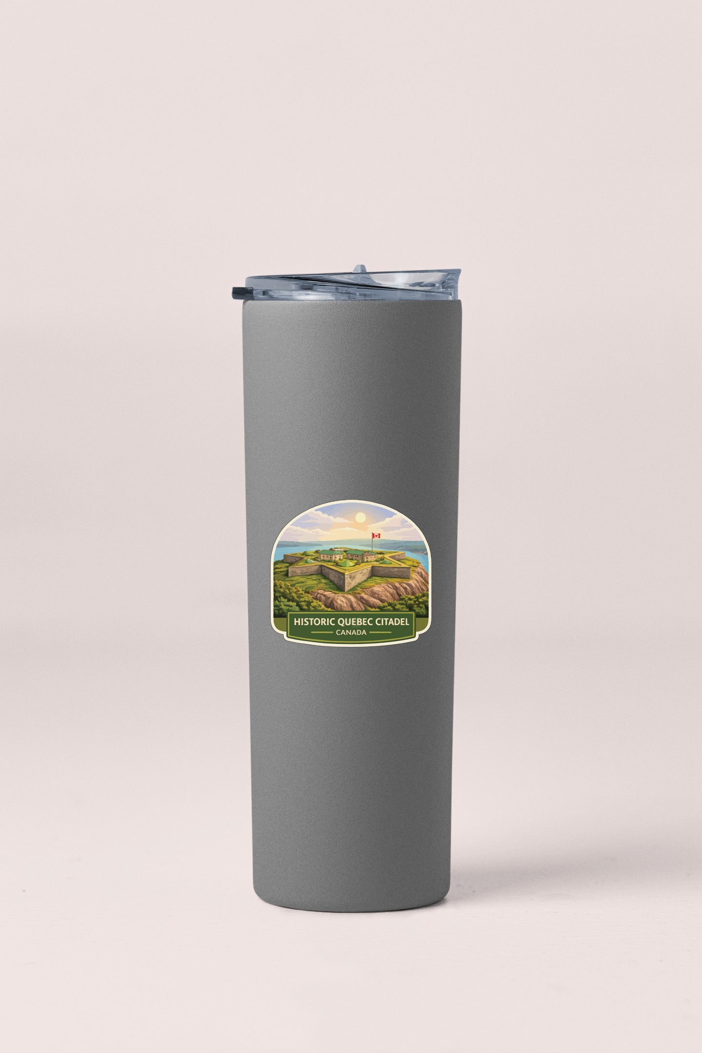 A gray insulated tumbler with a label depicting a scenic landscape.