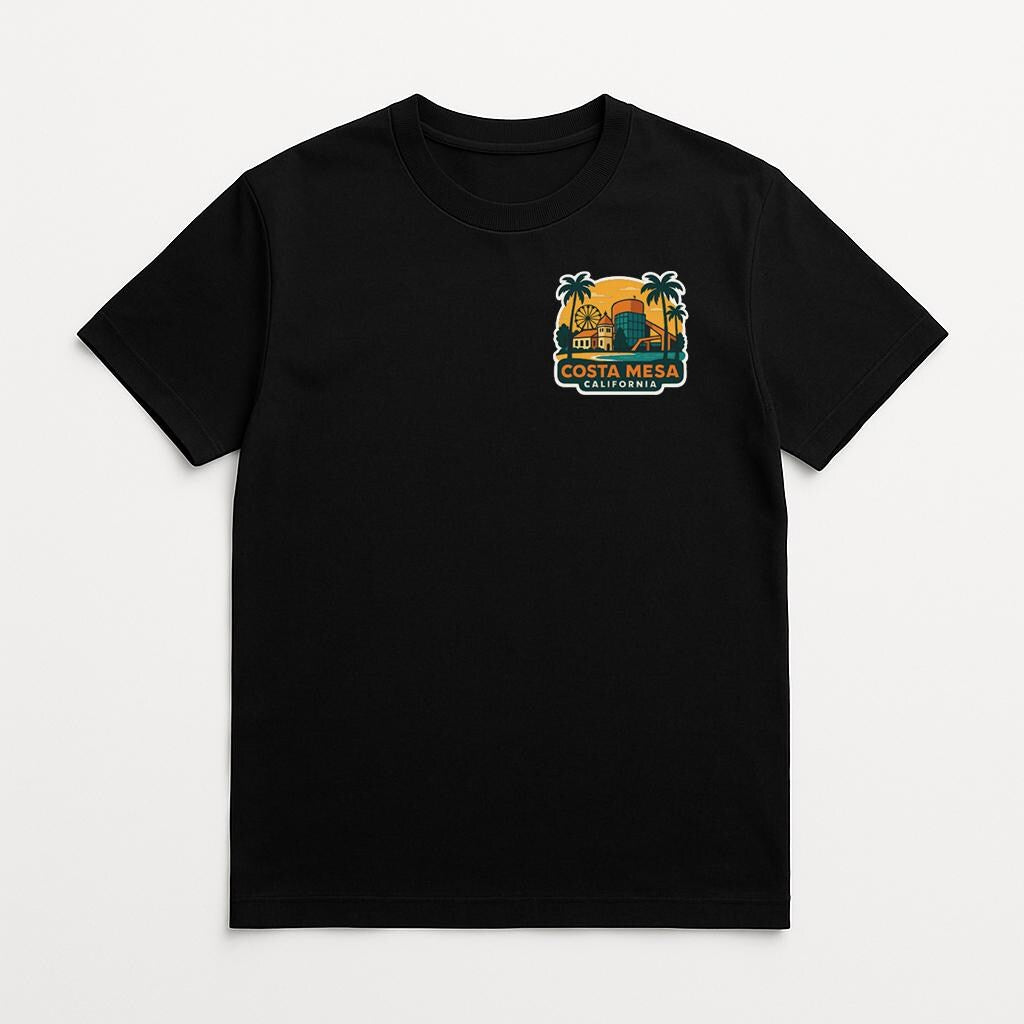 A black t-shirt with a graphic design on the front, depicting a tropical beach scene with palm trees and a sunset.
