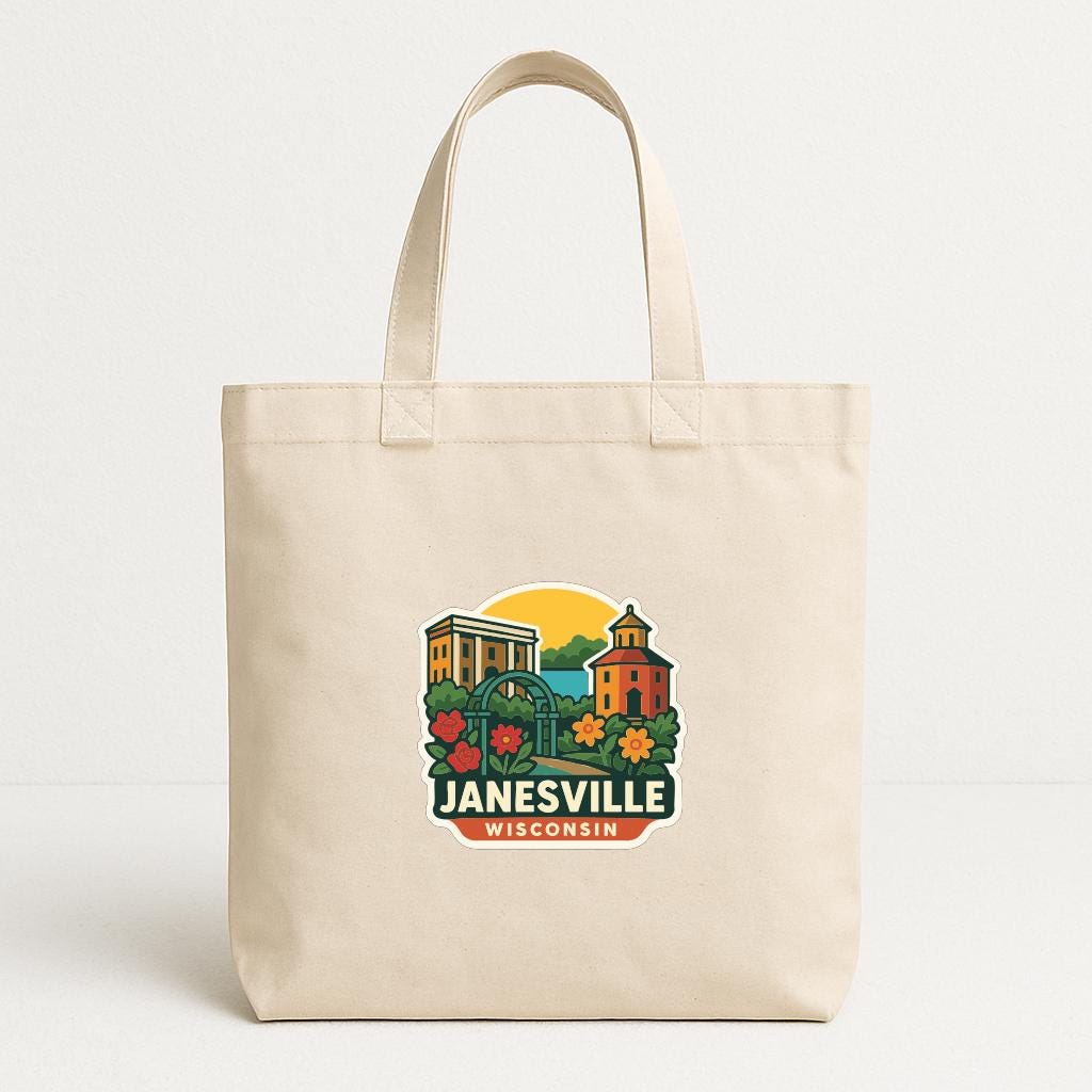 A beige tote bag with a graphic design featuring a building, flowers, and the text "Janesville, Wisconsin" printed on it.