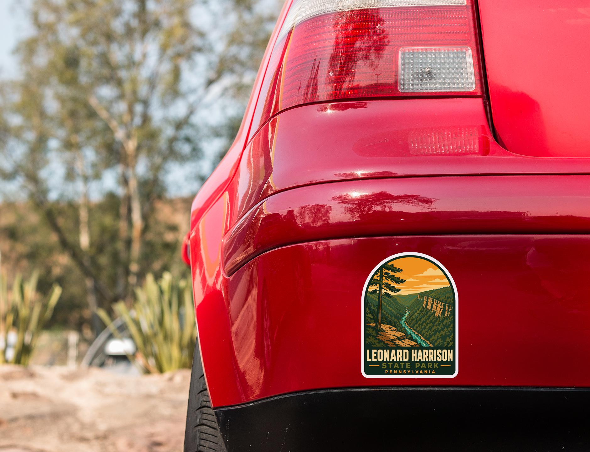 the rear end of a red car with a sticker on the back window that says "LEONARD HARRISON PENNSYLVANIA".