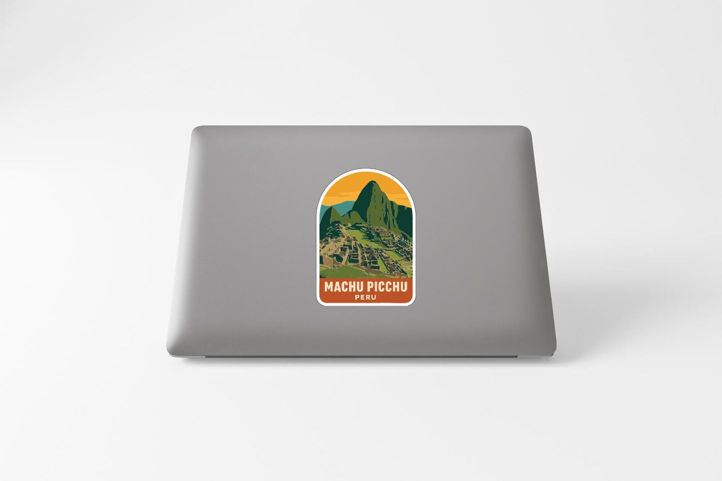 A sticker depicting Machu Picchu, the ancient Inca citadel, is placed on the back of a laptop.
