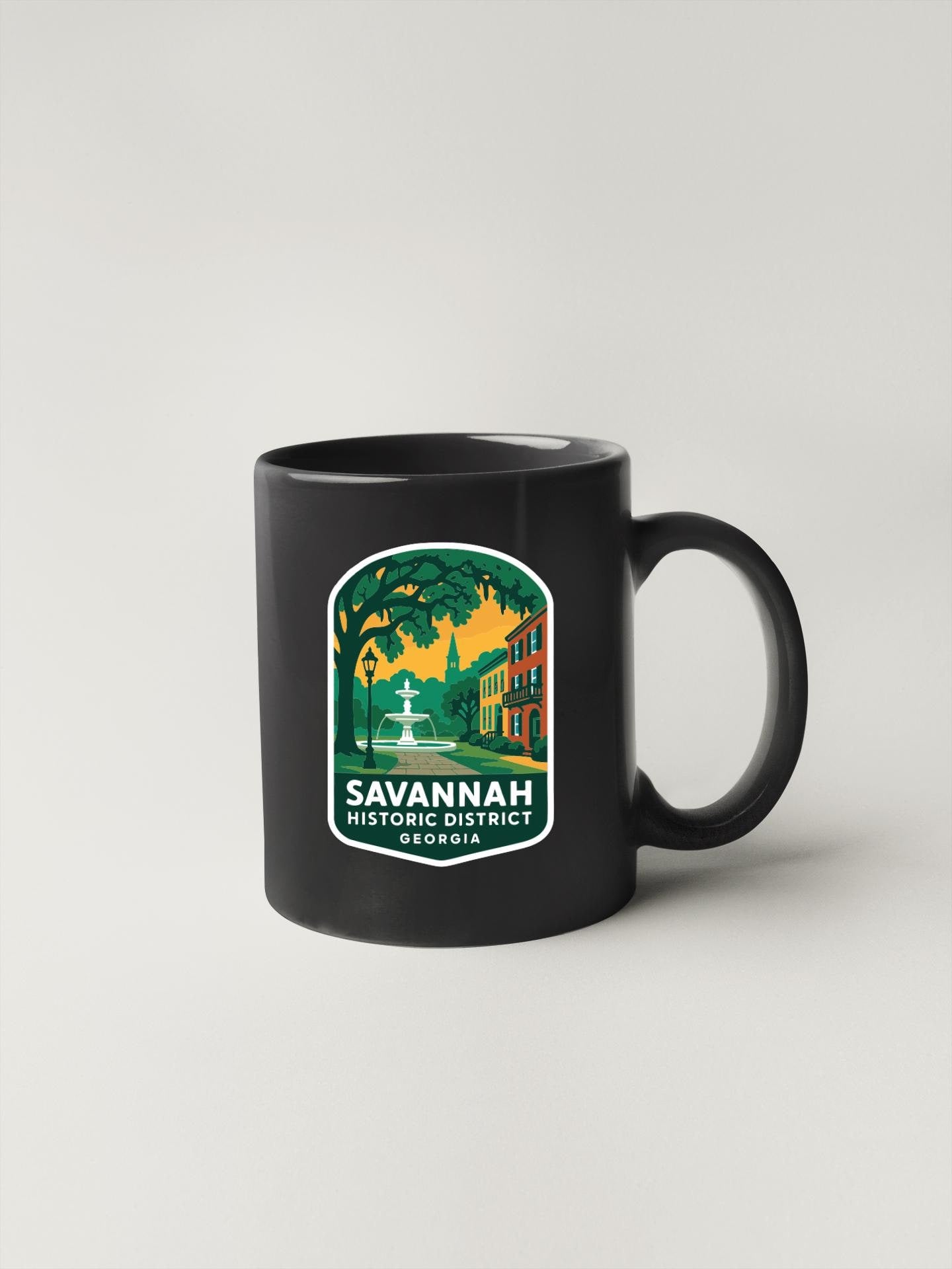 A black coffee mug with a graphic design depicting a historic district in Savannah, Georgia.