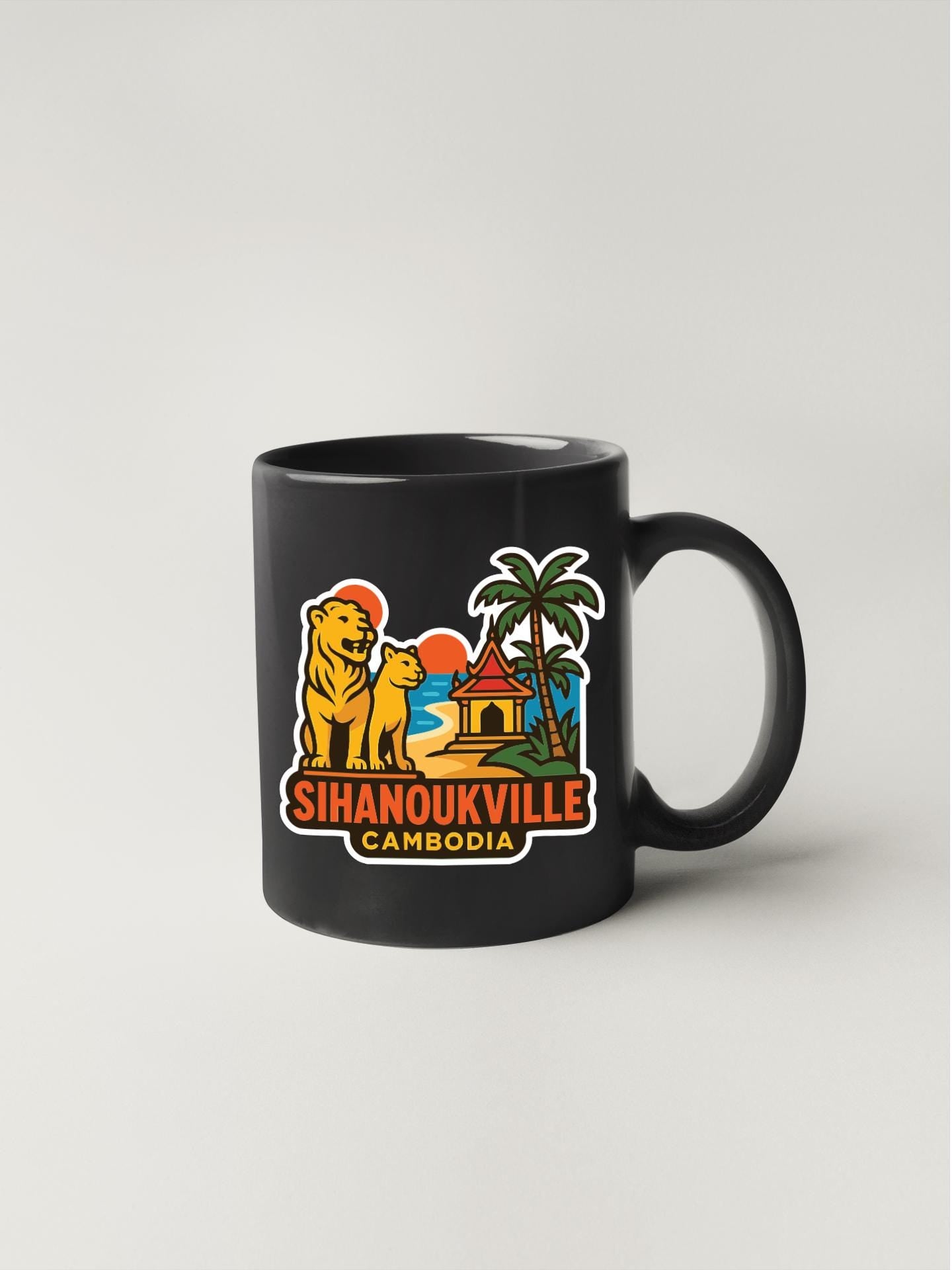 A black coffee mug with a colorful sticker depicting a tropical scene, including a lion, palm tree, and a building, along with the text "Sihanoukville Cambodia".