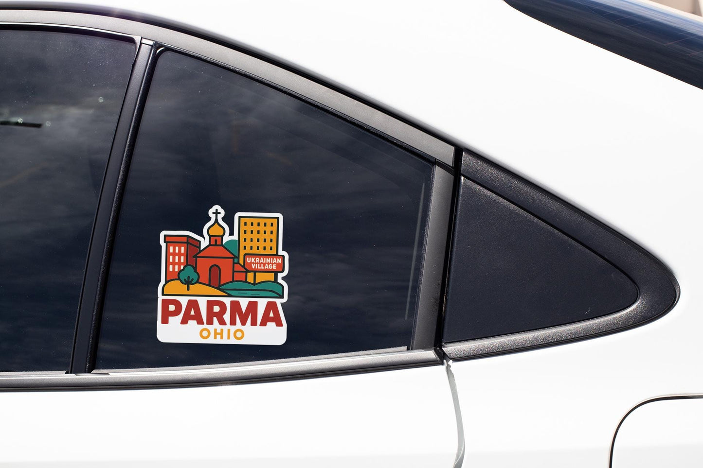 A sticker on the side of a car window, featuring an illustration of a cityscape with buildings and a church.