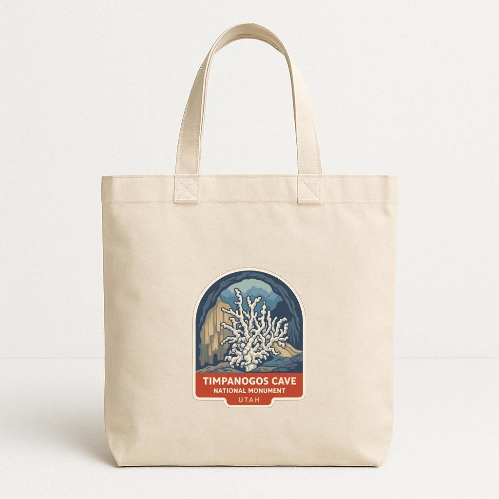 A beige tote bag with a printed label that says "TIMPANOGOS CAVE NATIONAL PARK UNIDOS".