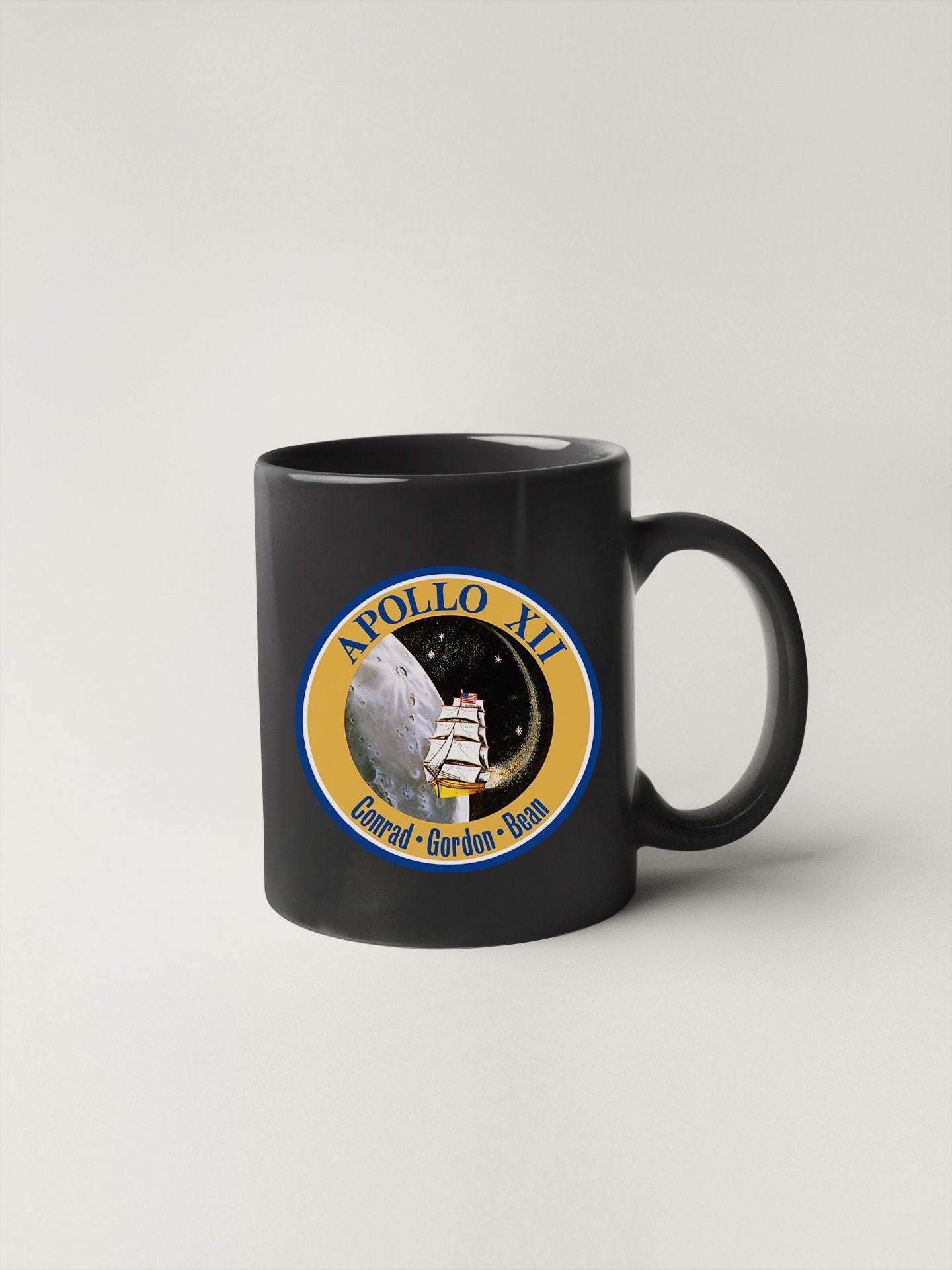 a black coffee mug with a picture of a space shuttle on it