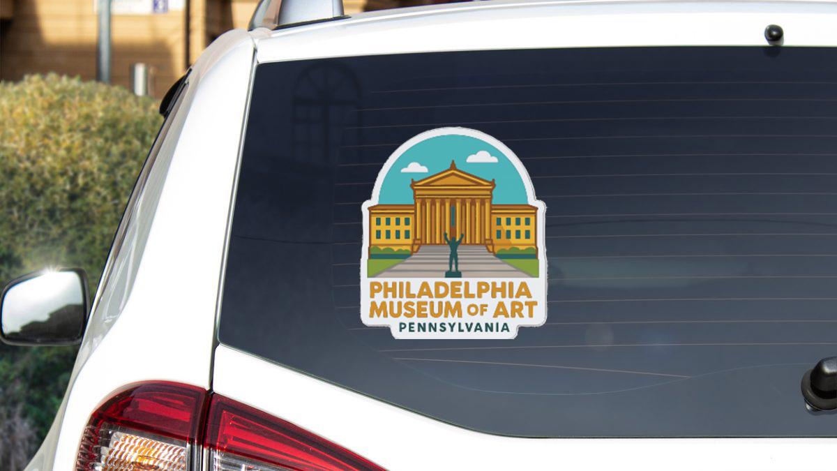 a sticker on the rear window of a vehicle, displaying the Philadelphia Museum of Art logo.