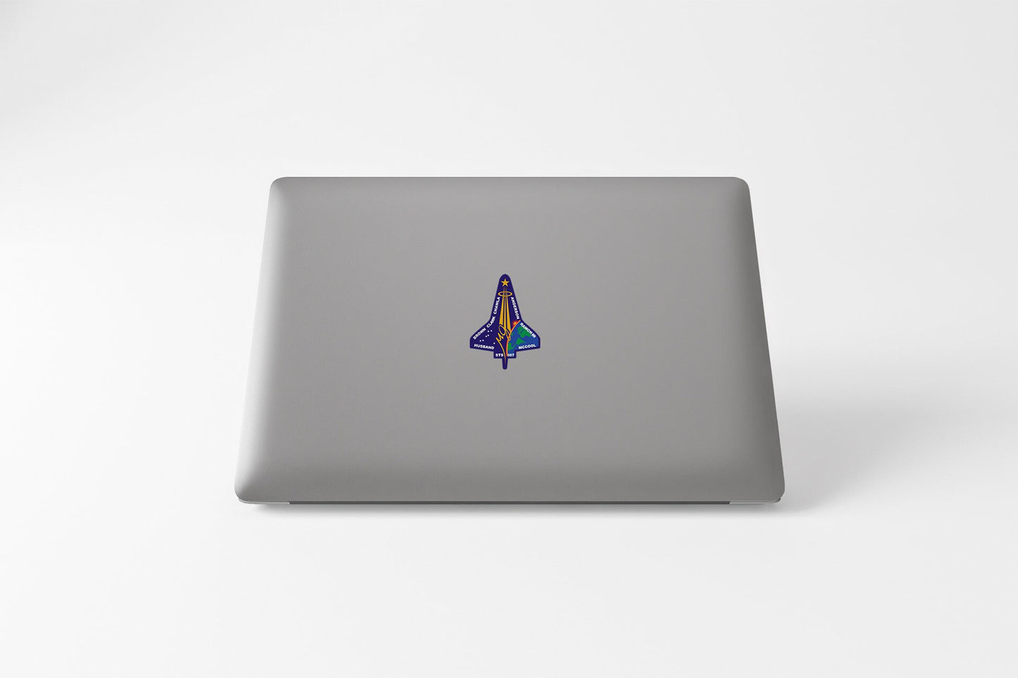 a laptop with a sticker of a rocket ship