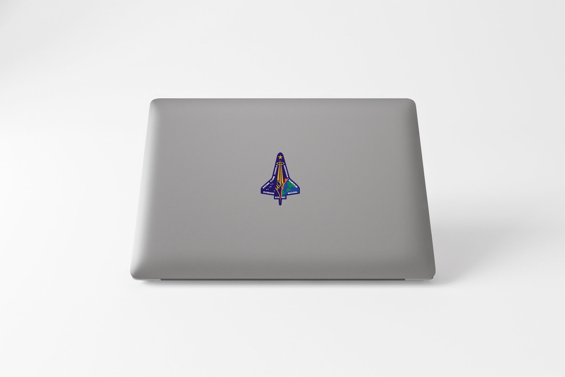 a laptop with a sticker of a rocket ship