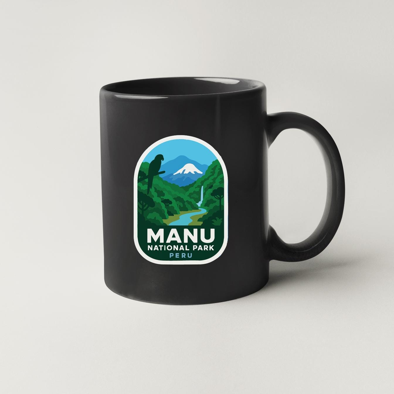 A black coffee mug with a label that says "MANU NATIONAL PARK PERU".