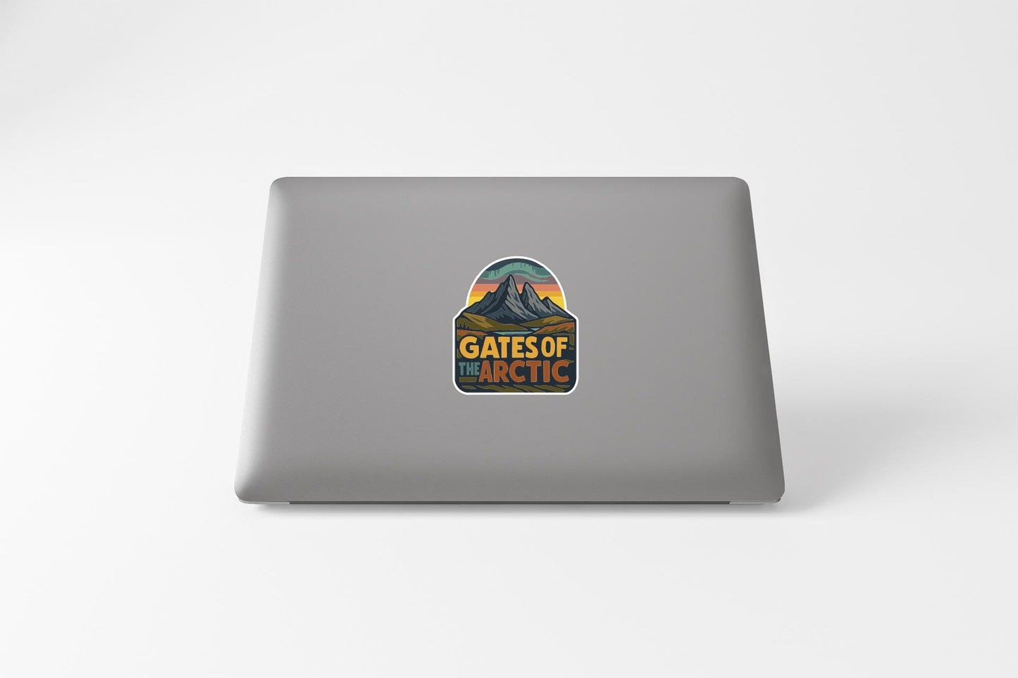 A sticker on the back of a laptop, featuring a mountain landscape with the text "GATES OF THE ARCTIC".
