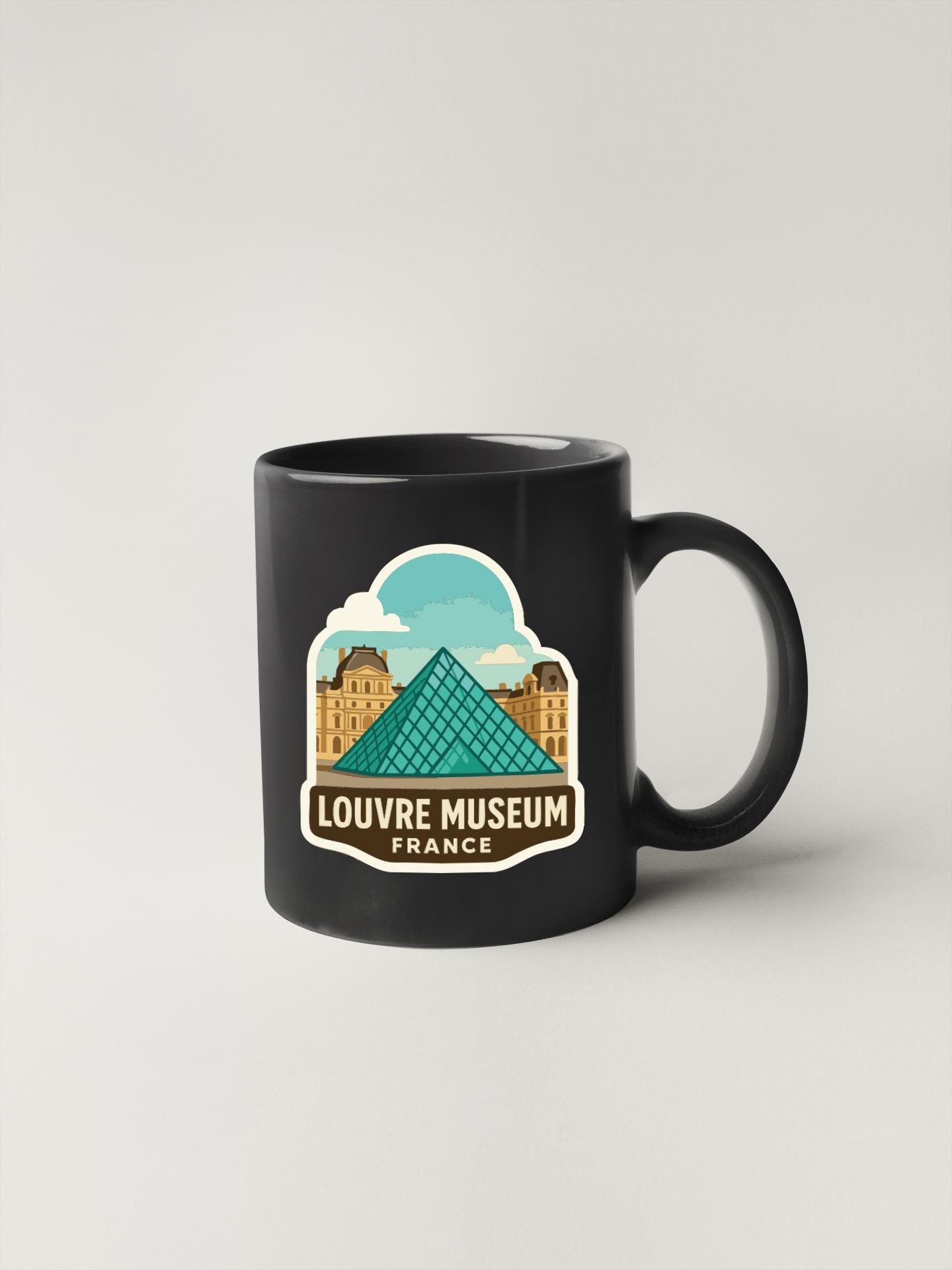 A black coffee mug with a graphic design featuring the Louvre Museum in Paris, France.