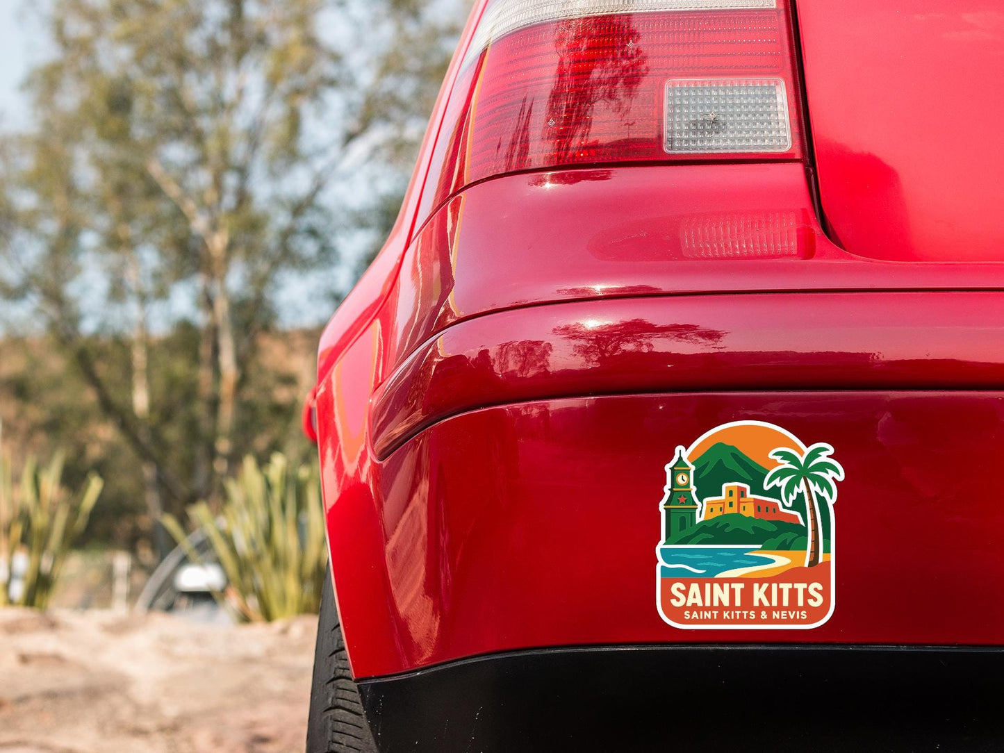 the rear end of a red car with a sticker on the trunk that features a tropical landscape with a castle and palm trees.