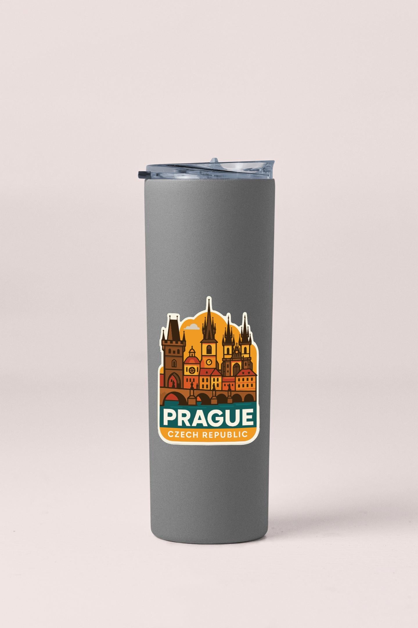 A gray insulated tumbler with a sticker depicting the Prague Castle and the text "Prague, Czech Republic" printed on it.