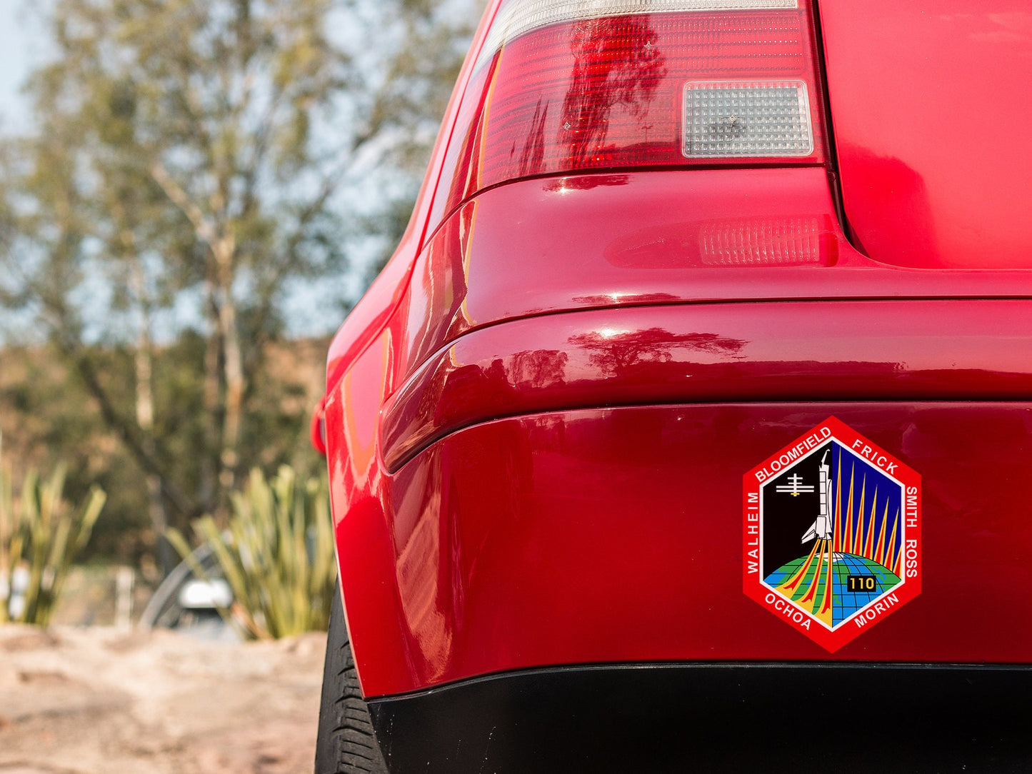a close up of a red car with a sticker on it