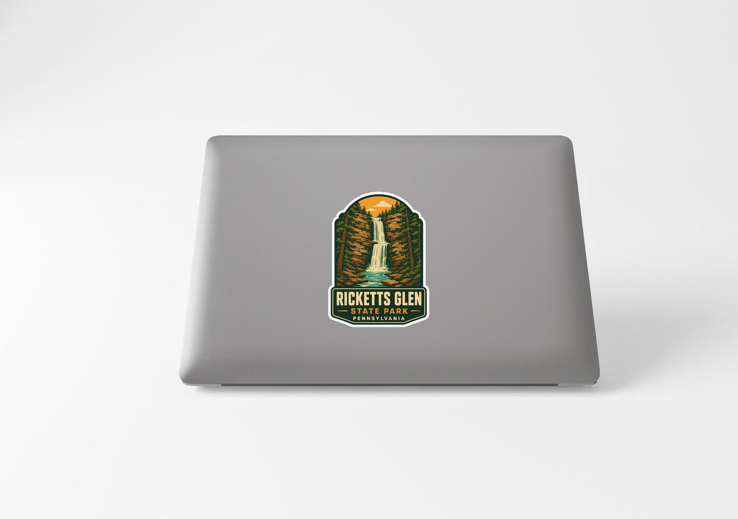 A sticker on the back of a laptop, featuring an illustration of a waterfall and the text "RICKETTS GLEN PARK".