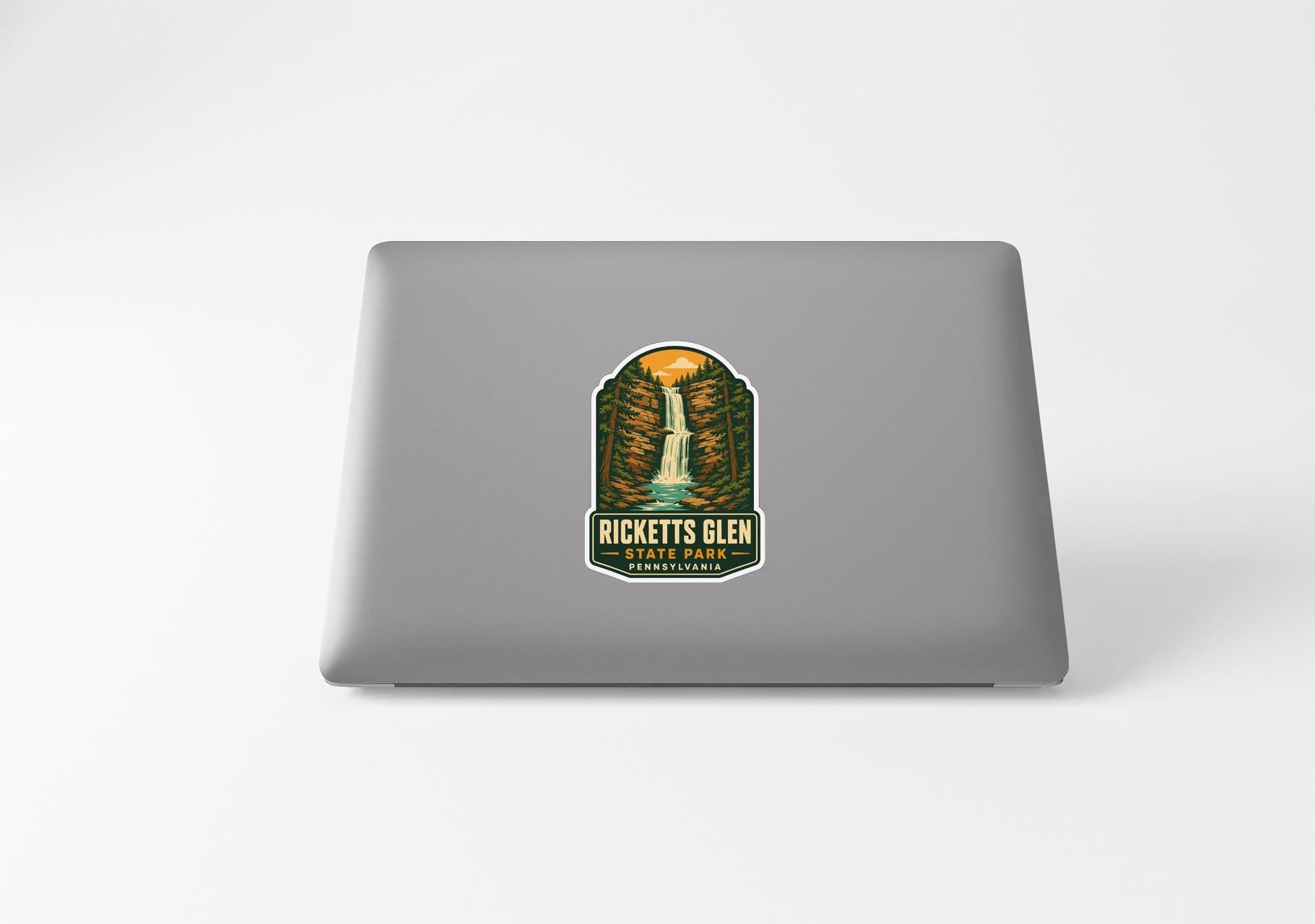 A sticker on the back of a laptop, featuring an illustration of a waterfall and the text "RICKETTS GLEN PARK".