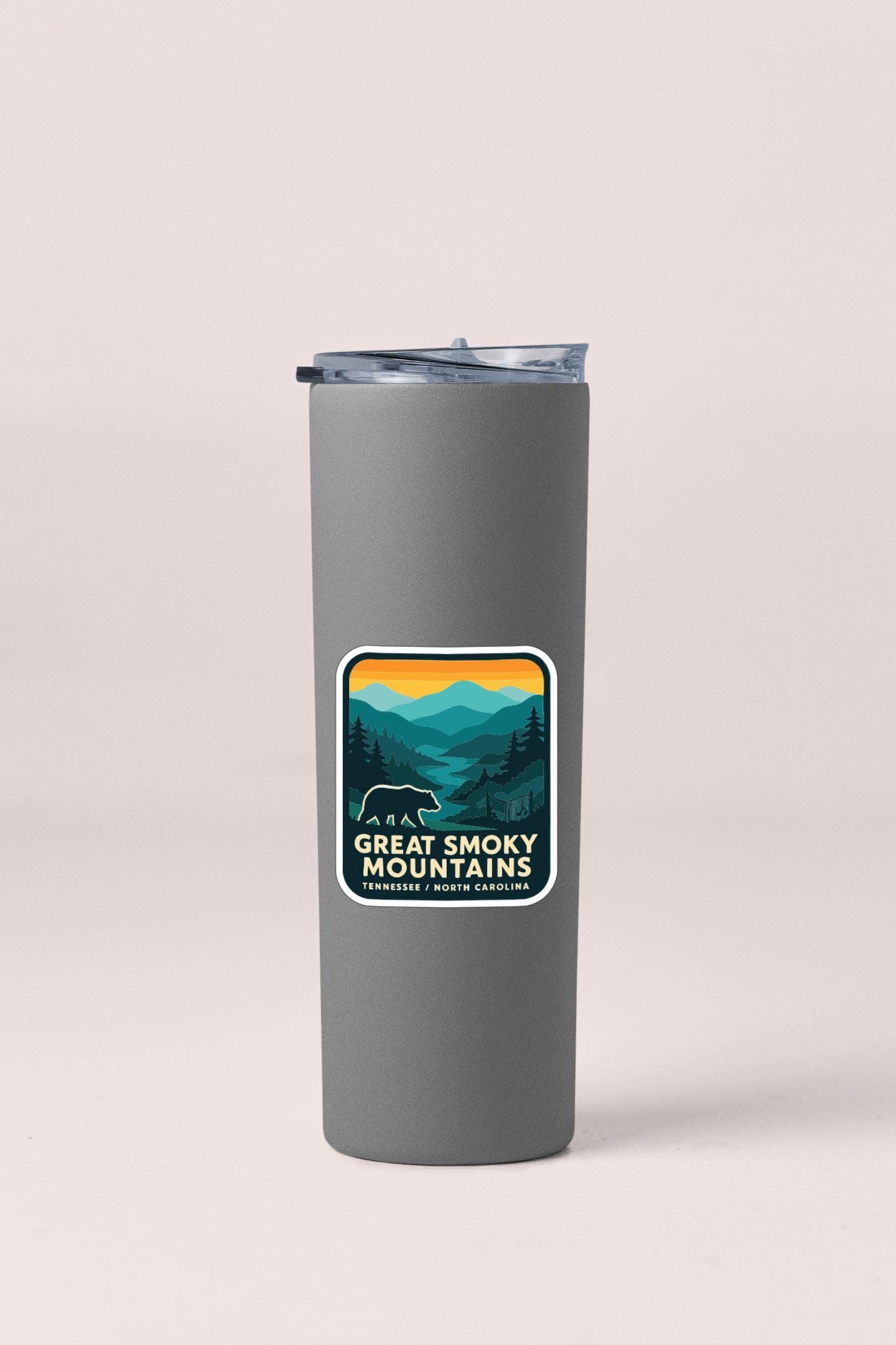 A gray insulated tumbler with a sticker featuring a mountain landscape and the text "Great Smoky Mountains National Park, Tennessee, North Carolina".